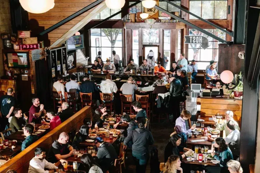 Los clientes comen y beben dentro de la cervecería 21st Amendment en San Francisco.